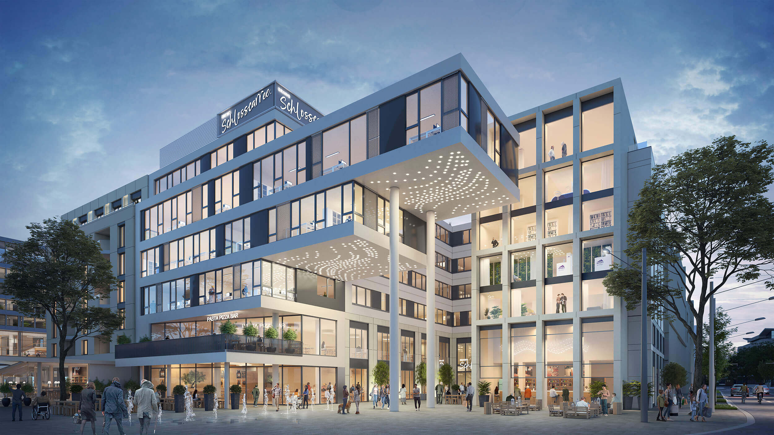 Großes, modernes Gebäude mit vielen Fenstern an der Front und umgeben von Bäumen.